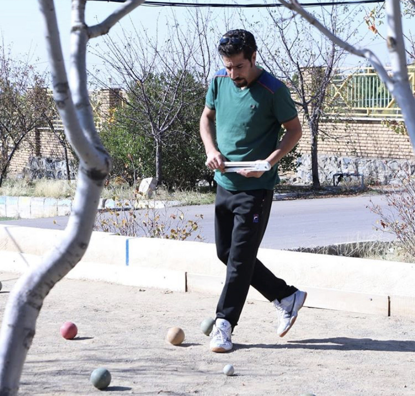 man standing on bocce ball court