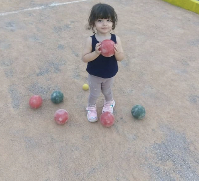 small child holding bocce ball