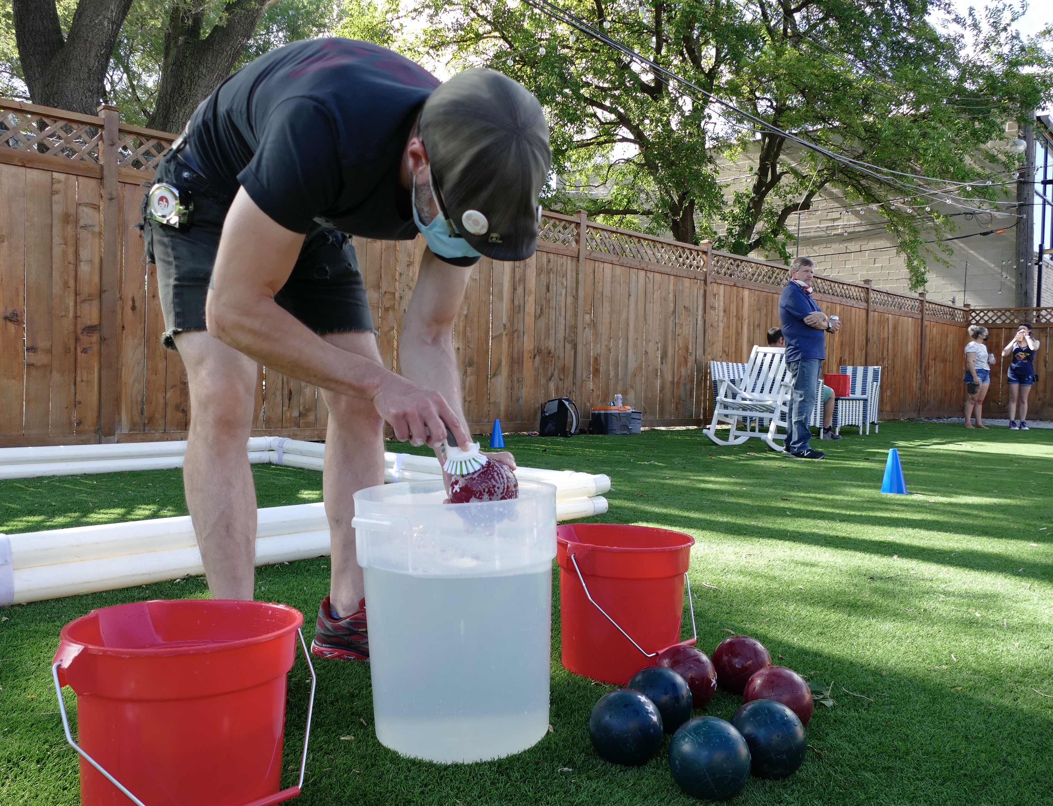 man washes bocce balls during pandemic