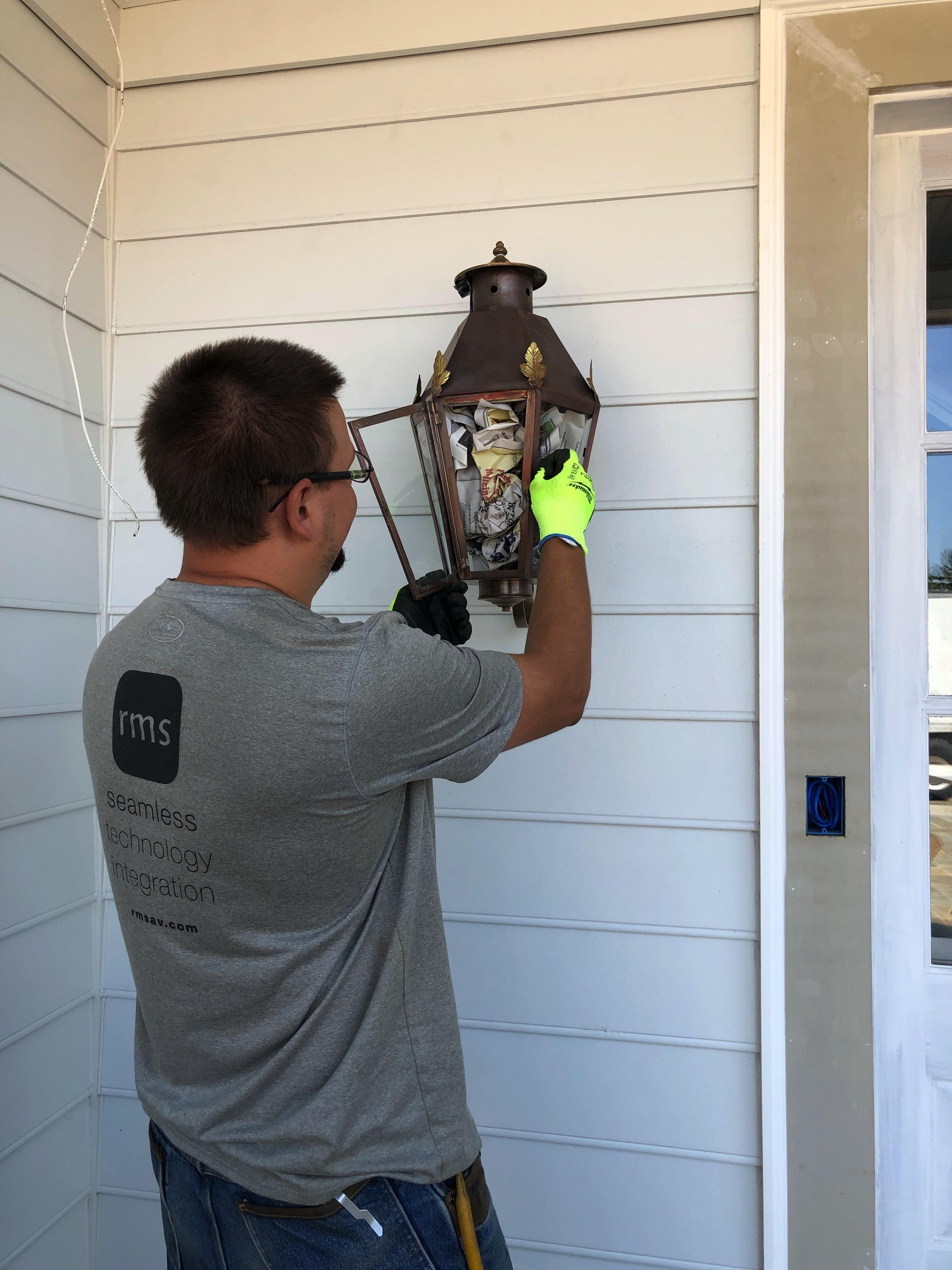 Electrician working hard on exterior light