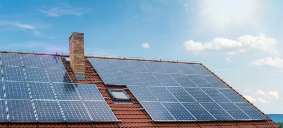 lohnt sich eine photovoltaikanlage zur miete? Anlage auf einem roten Dach mit blauem Himmel