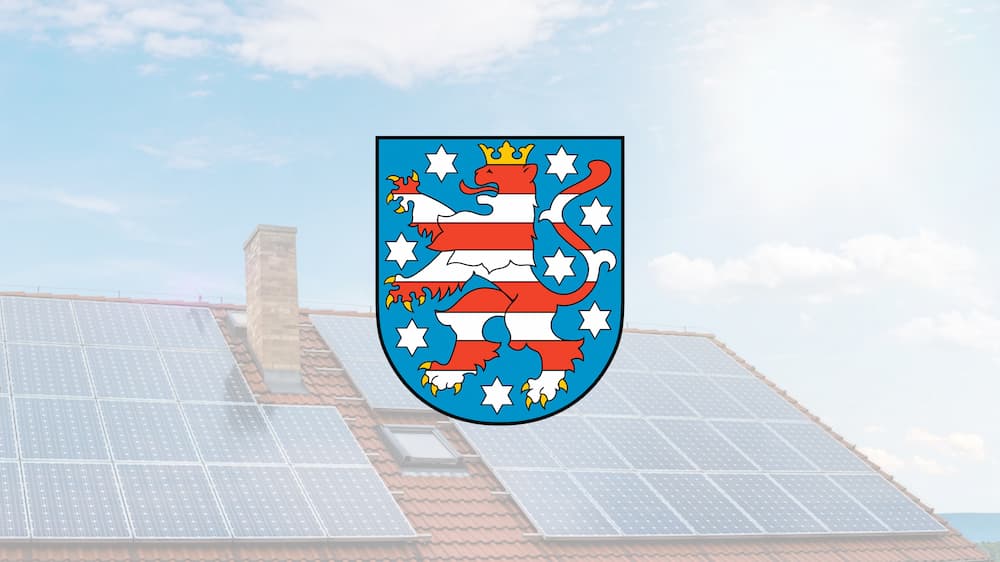 Wappen von Thüringen mit Solarhaus im Hintergrund
