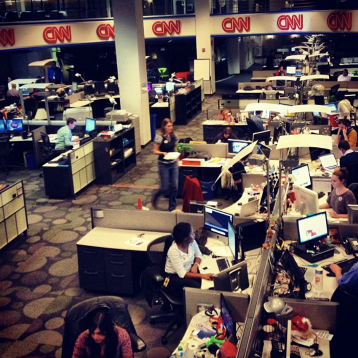 The CNN newsroom on election night 2012. A room of low-walled cubicles with people seated at desks in front of computer screens.