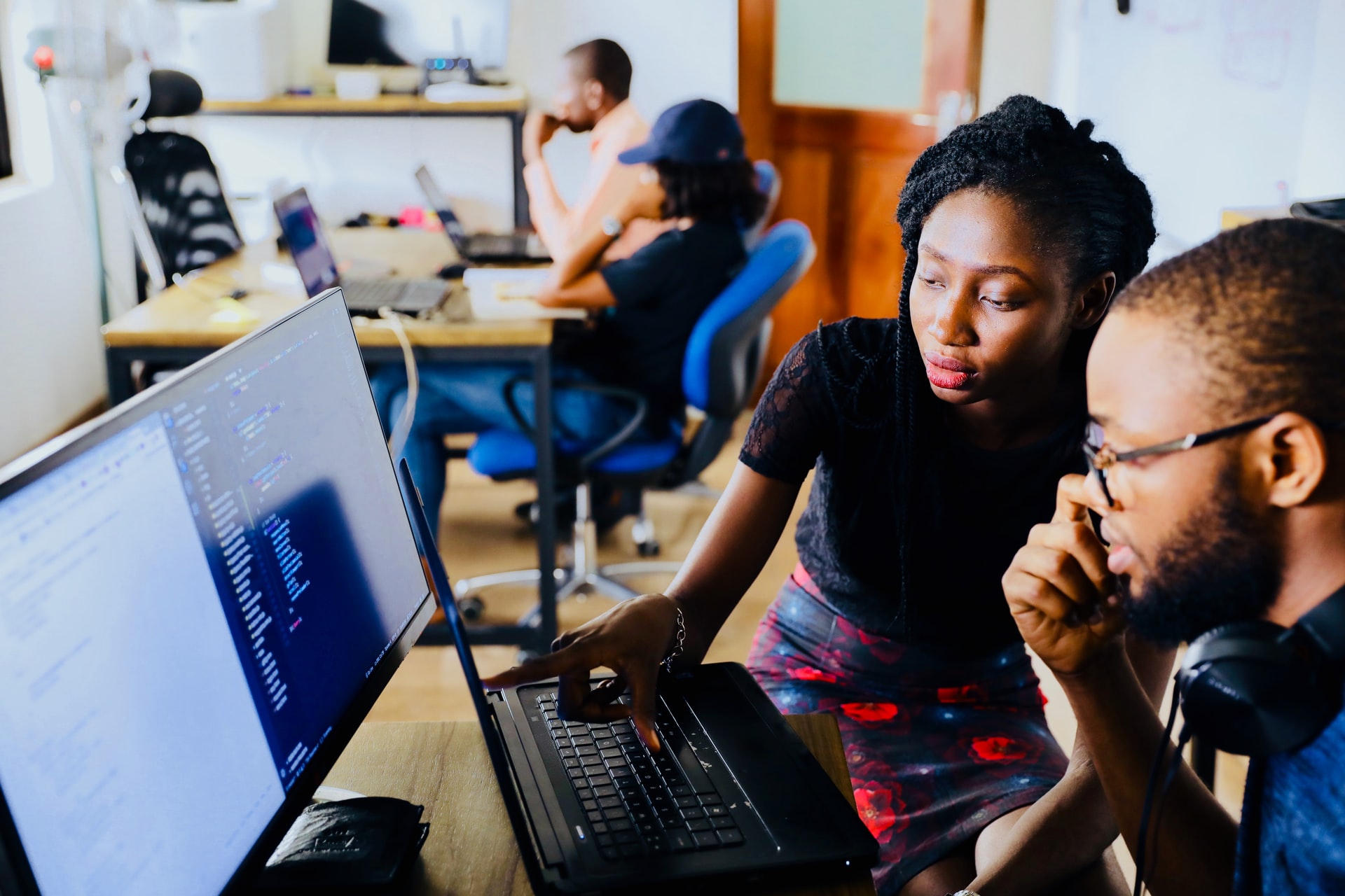 Teacher and student reviewing code together in classroom