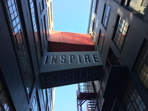 a building that shows a passage with the words "inspire" and "exchange" written on a bridge