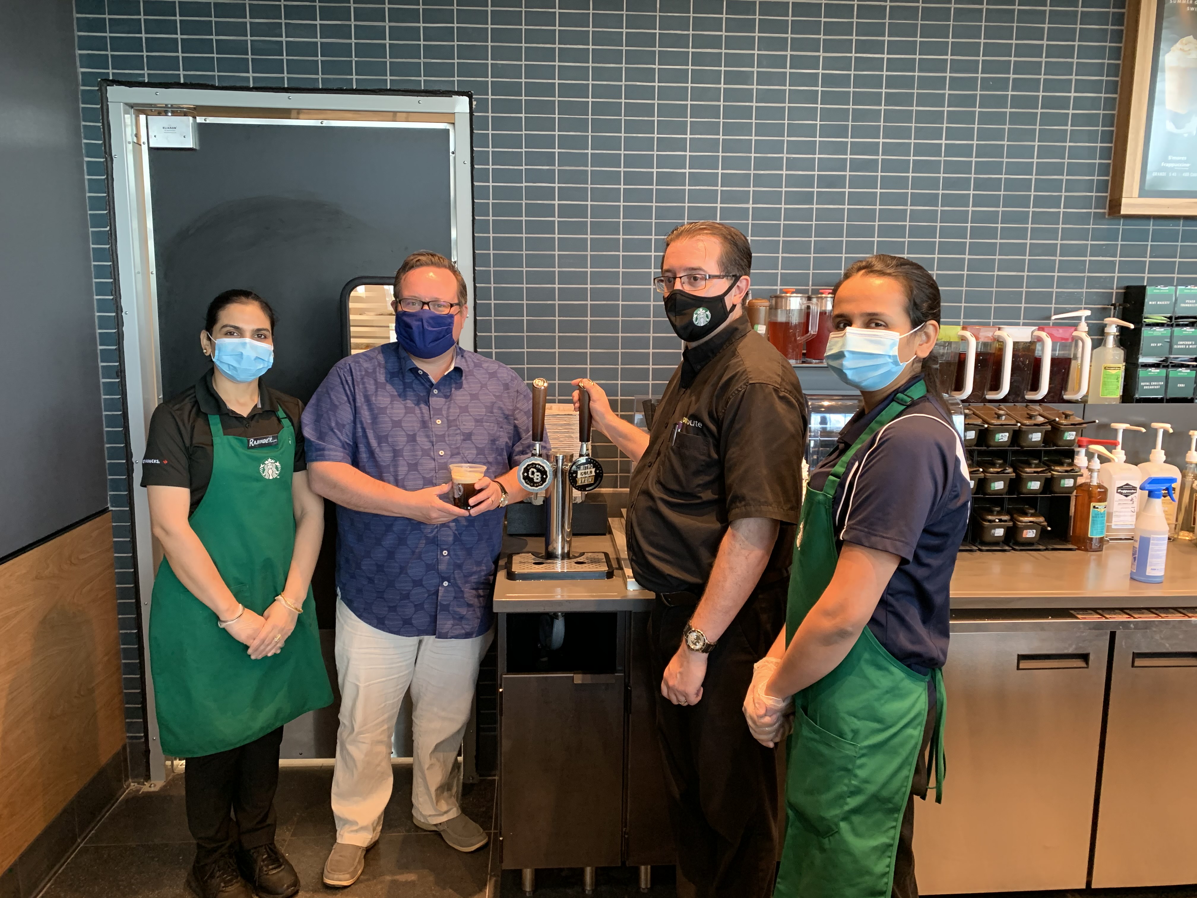 Employees by a "Cold Brew" tap
