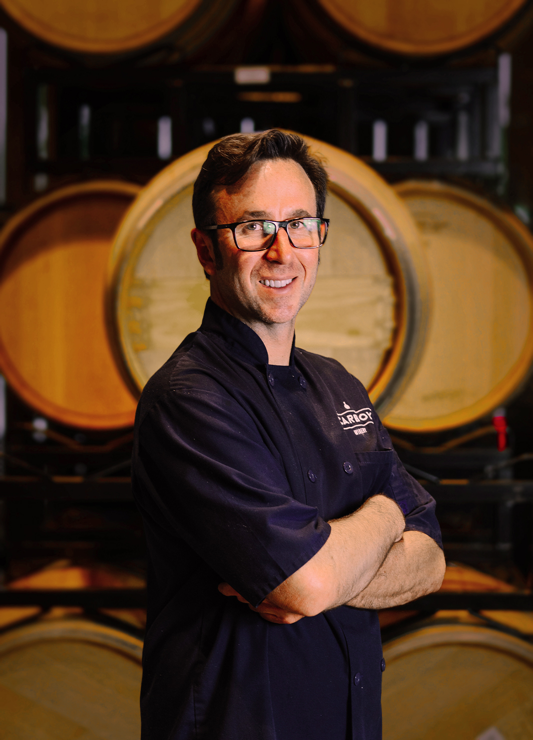 Carboy Executive Chef, Scott Hybbeneth, standing in front of wine barrels