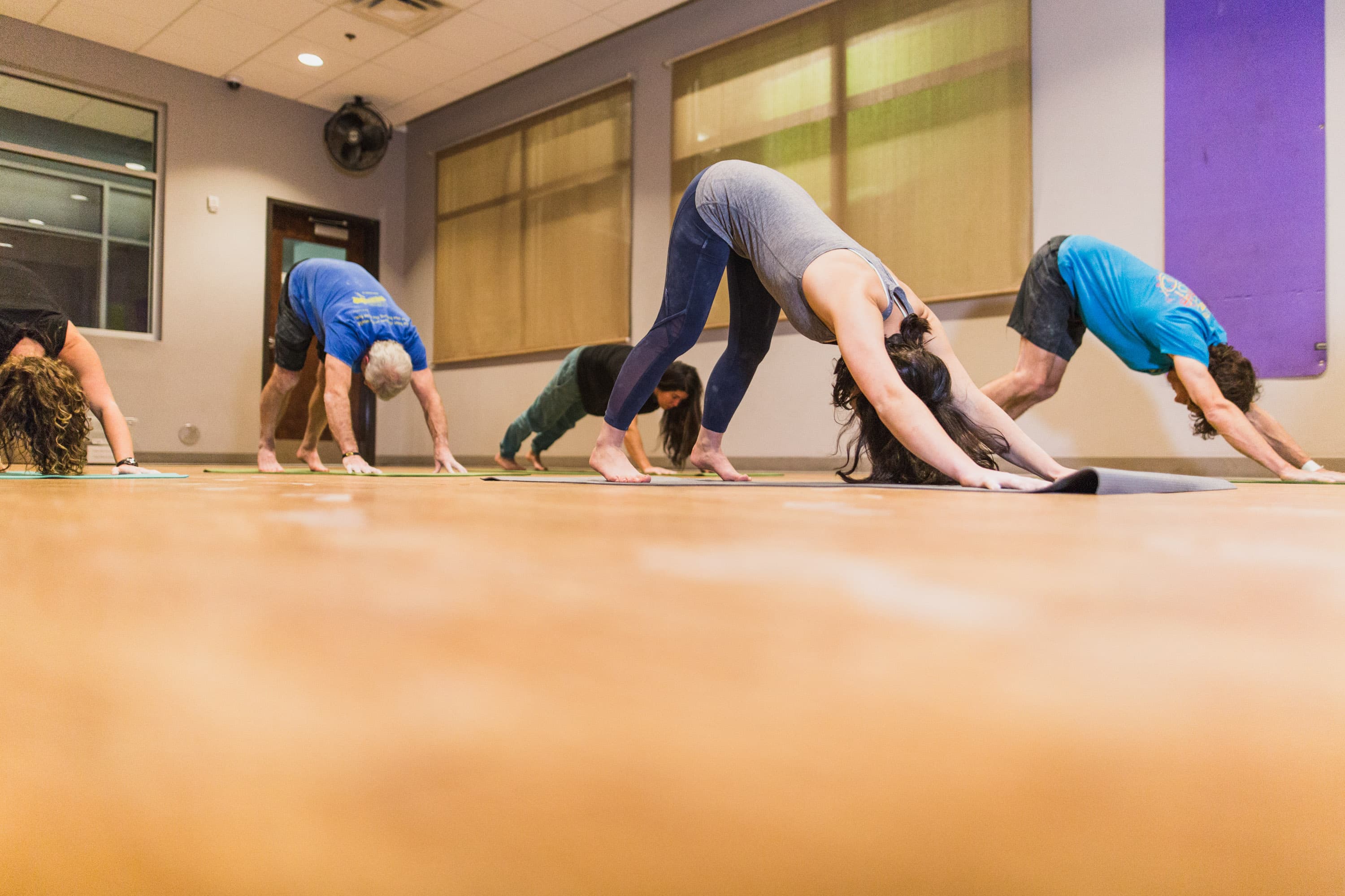 a group of women do yoga in an airy space.
