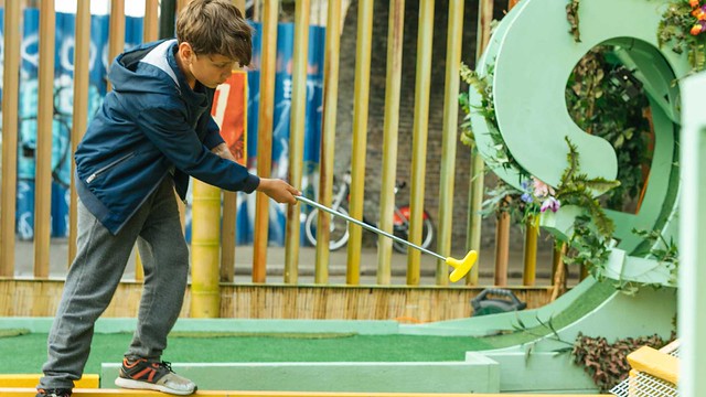 boy hitting a golf ball on plonk crazy golf course