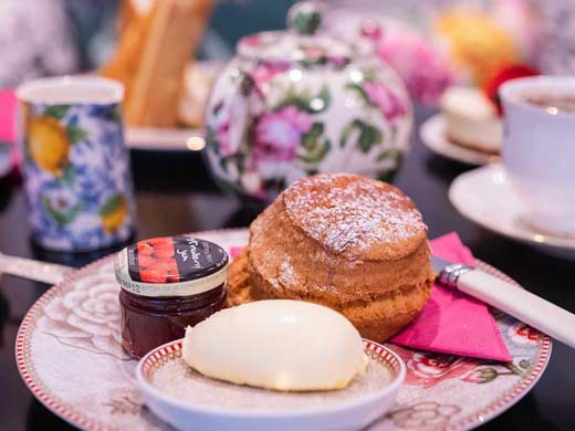 scone on a plate with jam and clotted cream at B Bakery