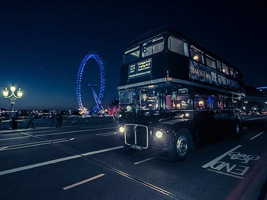 Ghost bus Tours bus going past The London Eye