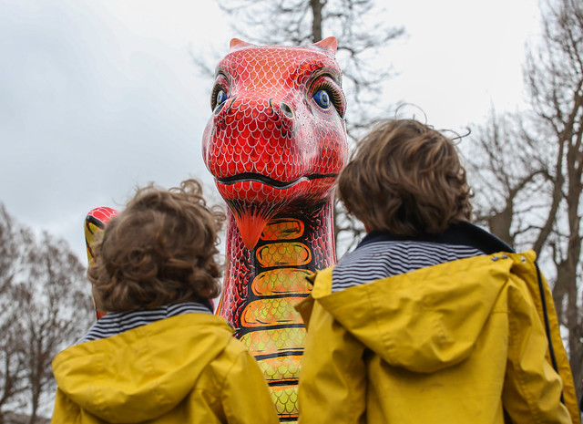 Two children looking at a sculpture of a dinosaur