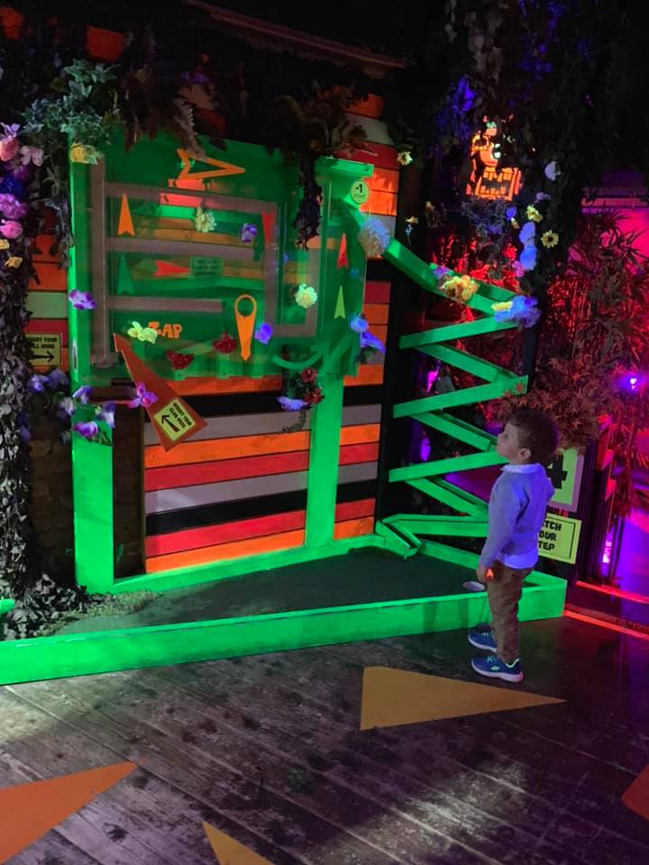 boy on a neon golf course at plonk crazy golf in camden