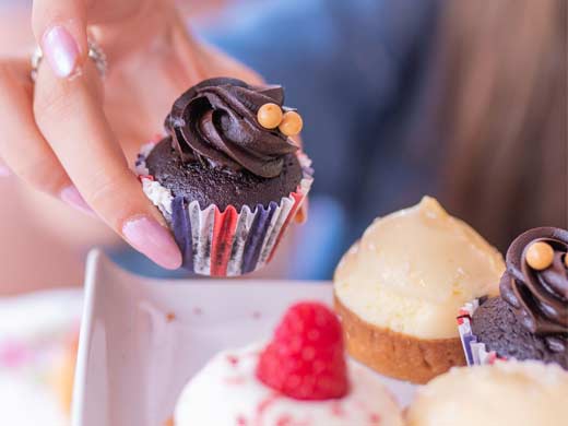 hand holding a chocolate cupcake at afternoon tea at B Bakery