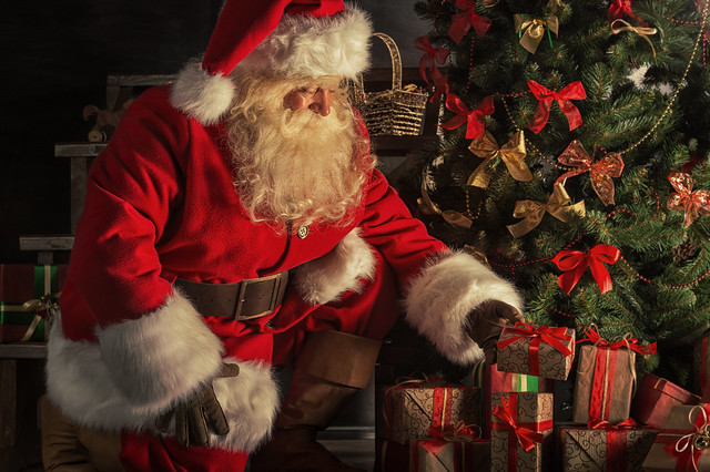 Santa Claus placing gifts under the Christmas tree