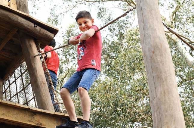 boy on high ropes course at kew gardens new children's playground