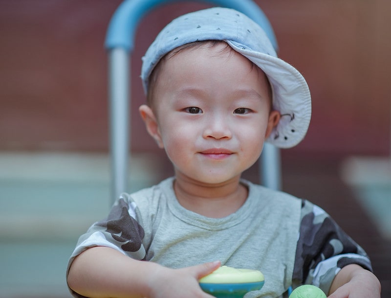 Boy in a blue cap sitting at the table, inspiring fantastic boys' names beginning with F