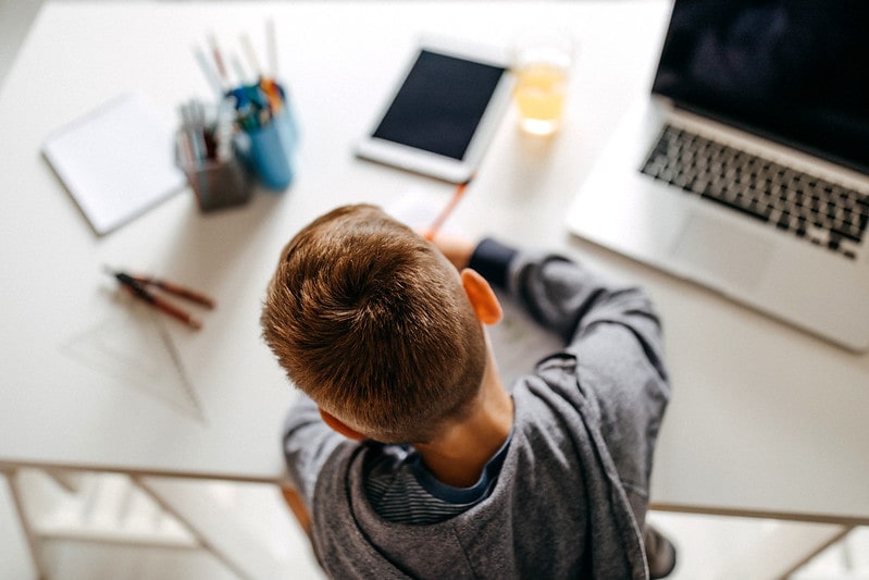 Young boy sitting in his room doing his non verbal reasoning homework.