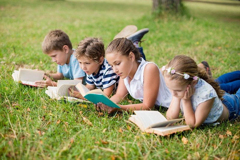 Children reading different Oxford Reading Tree levels in a field.