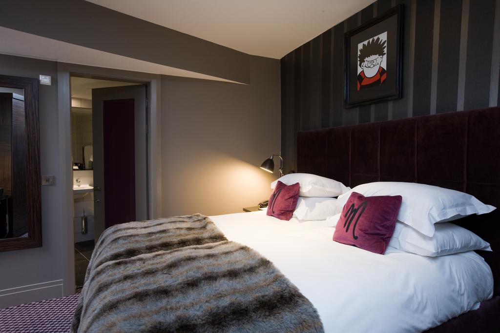 Luxurious bedroom with picture of Dennis the Menace hanging on the wall.