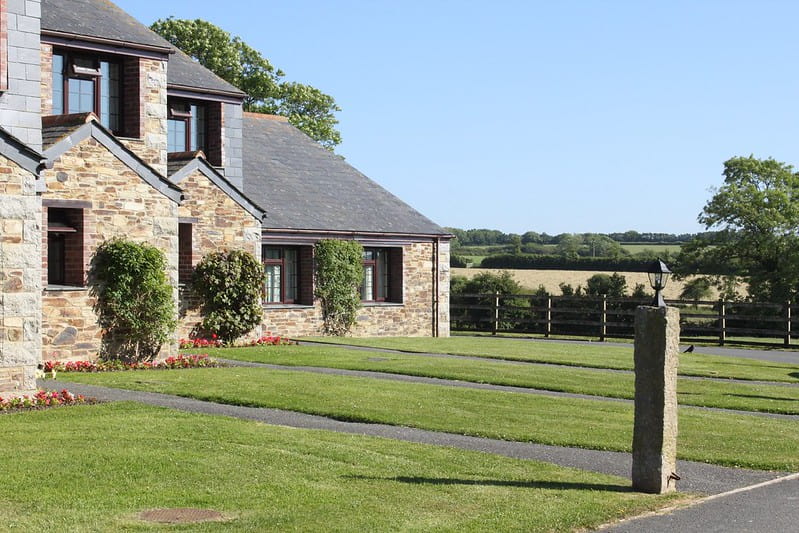 Cottages at The Olde House, Cornwall surrounded by fields and greenery.