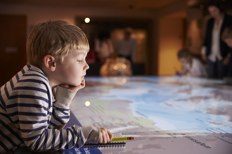 A KS2 child gazes intently at a large map.