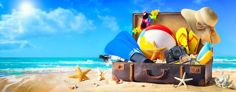 Suitcase filled with beach holiday essentials.