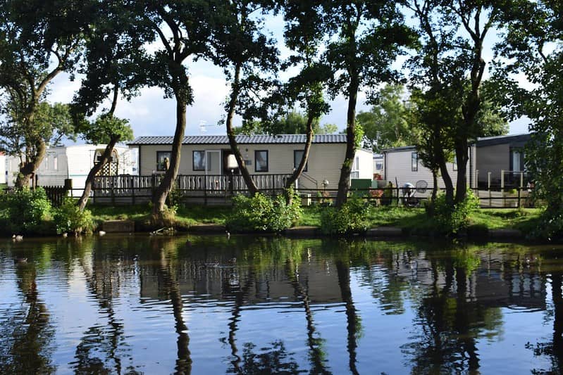 Lodge overlooking the fishing pond surrounded by trees.