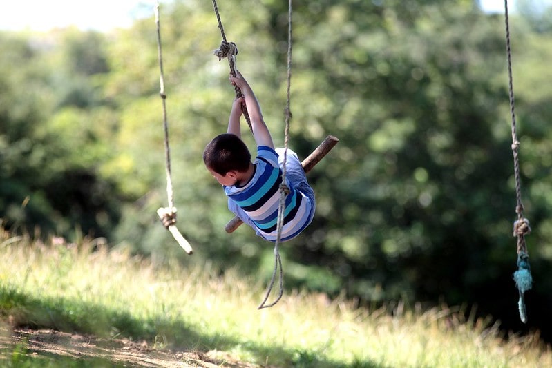 Boy on a swing outdoors at Trevella Holiday Park, Newquay.