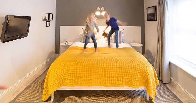 Kids jumping on the bed in the room at Watergate Bay, Newquay.