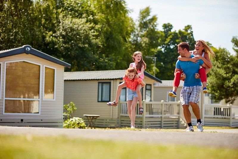 Family having a piggyback race outside on staycation in Dorset.