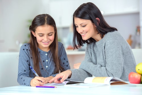 Mum and daughter smiling while learning spelling.