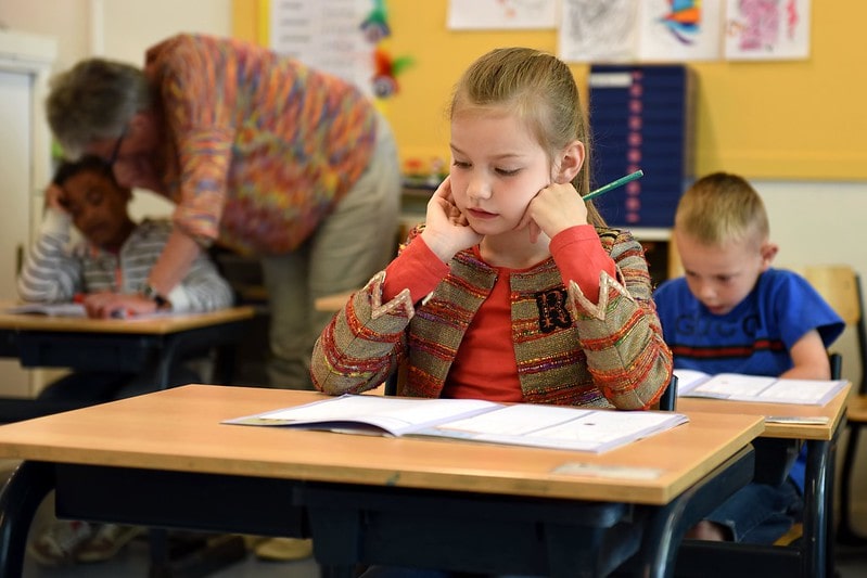 Girl at her desk in school sitting a maths exam.