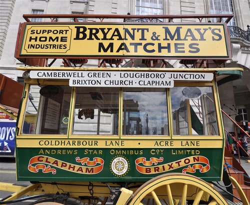 Victorian horse drawn bus with destinations written on side.