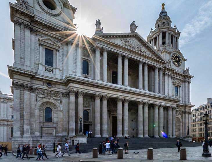 The exterior of St Paul's Cathedral in London against a blue sky.