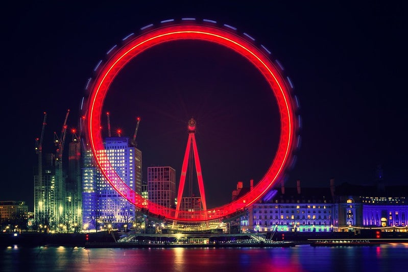 The London Eye lit up in red at night time.
