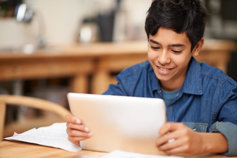 Boy studying for his thirteen plus exam using a tablet.