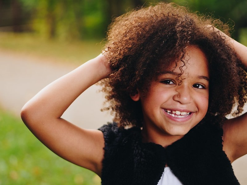 Girl laughing with her hands on her head.
