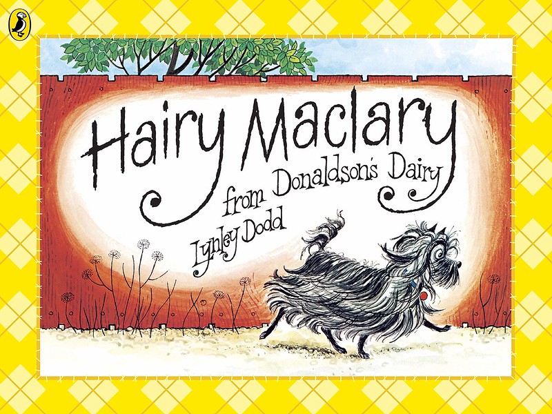 Cover of Hairy Maclary: a black dog with a long coat is walking down a path, with a tall red fence behind it.