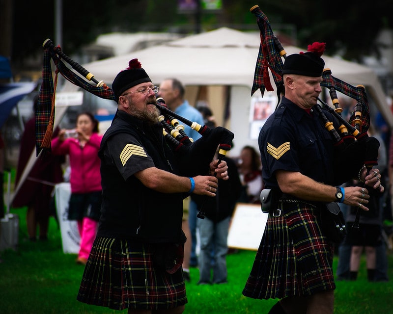 Men in traditional Scottish dress playing the bagpipes.