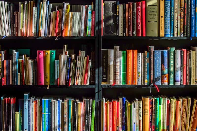 A bookshelf containing lots of colourful books.
