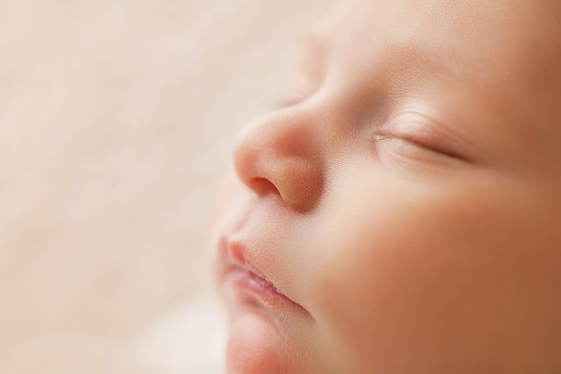 Close up of a sleeping newborn baby's face.