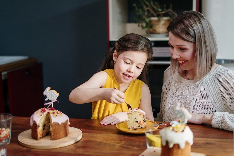 Mum and daughter out at a restaurant eating cake.