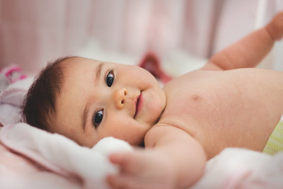 Sweet baby lying on its back reaching out towards parents.