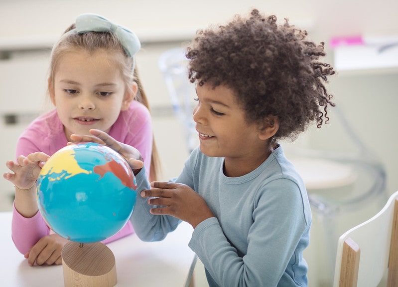 Kids looking at a globe for their non verbal reasoning test.