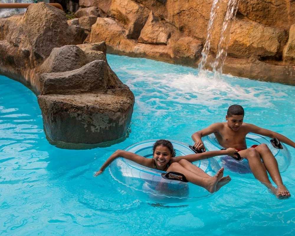 Two friends float around the lazy river.