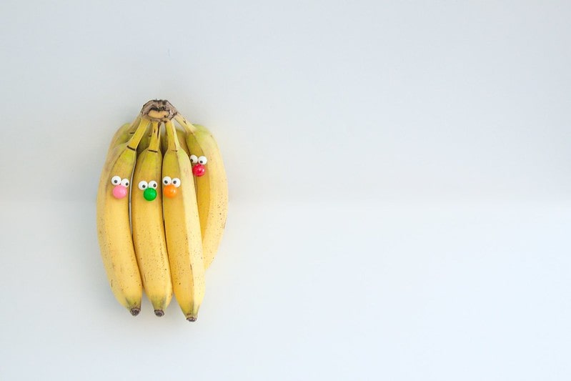 A bunch of bananas with googly eyes and coloured beads stuck on for noses.