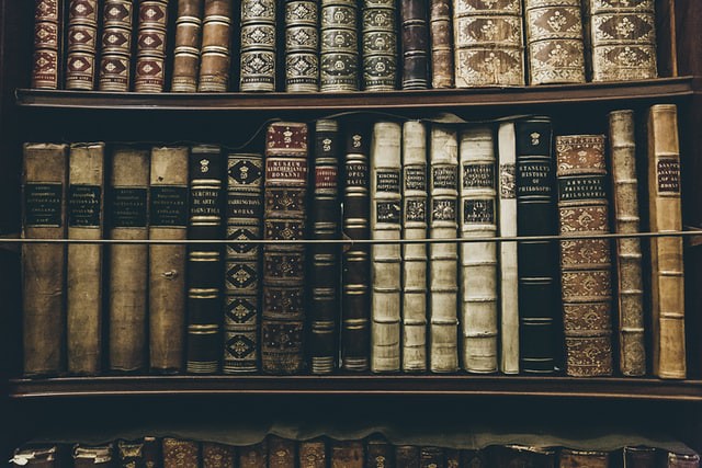 Old bound books sitting on the bookshelf.