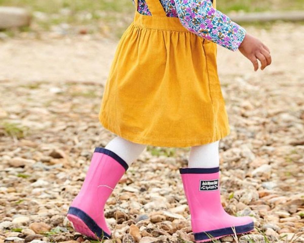 Little girl wearing pink Jojo Maman Bebe Classic Wellies.