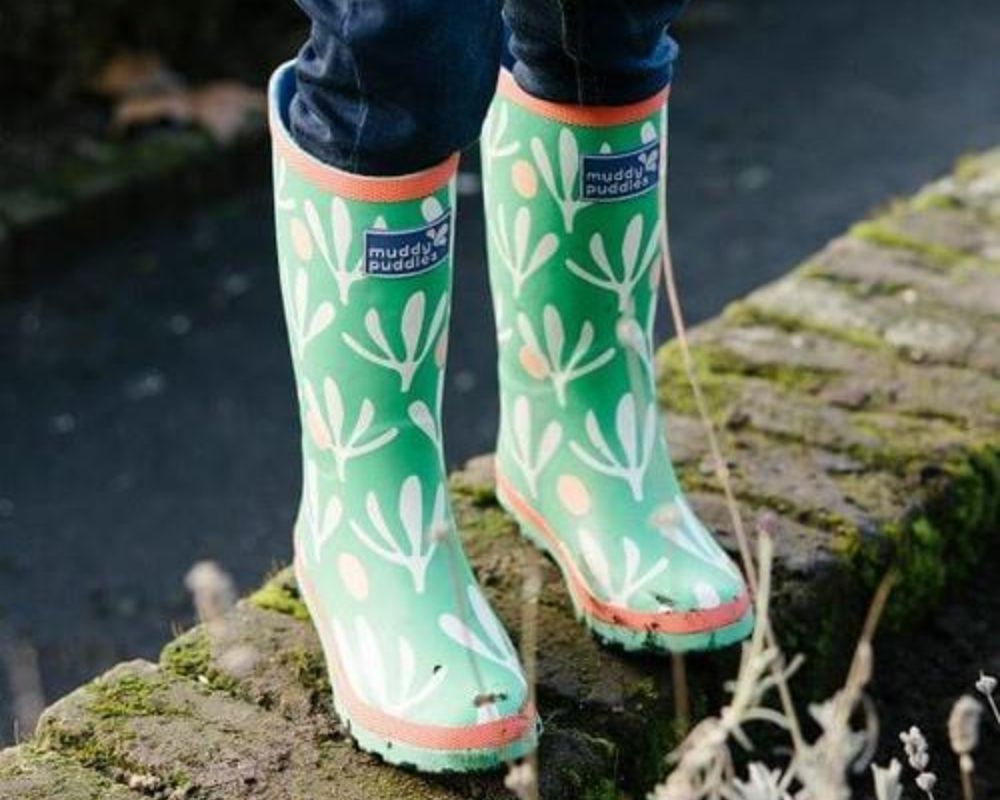 Child wearing Green Muddy Puddles Puddlestomper boots.